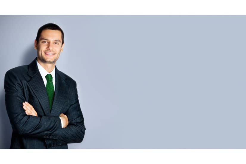 Happy businessman with crossed arms with green necktie