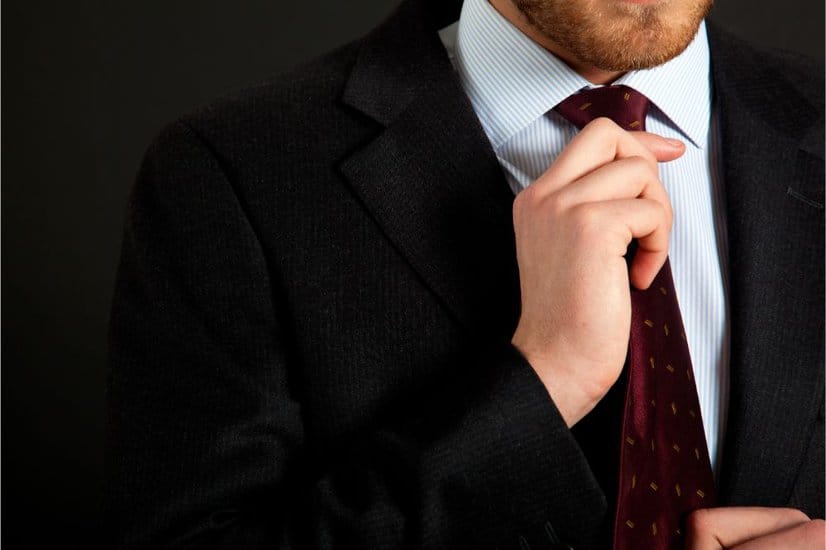 Detail of young businessman correcting a tie