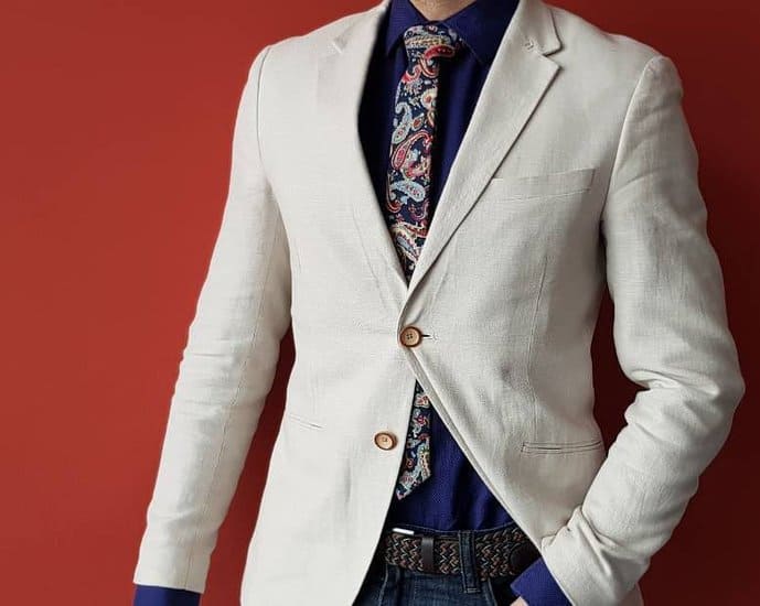 Tan blazer, navy blue shirt, and printed tie